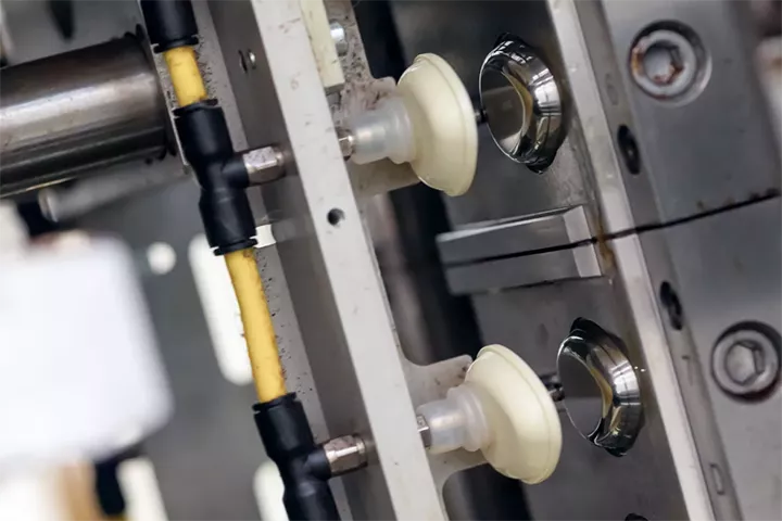 Zoom in on two ivory oval spoons just injected and removed from the mould by an automated robot