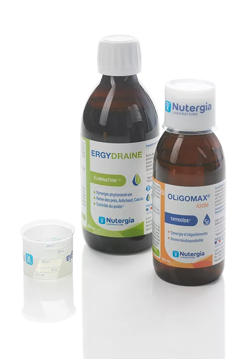 Two Nutergia IML bottles and caps. There is a cup next to one bottle and a cup on the cap of the second bottle.