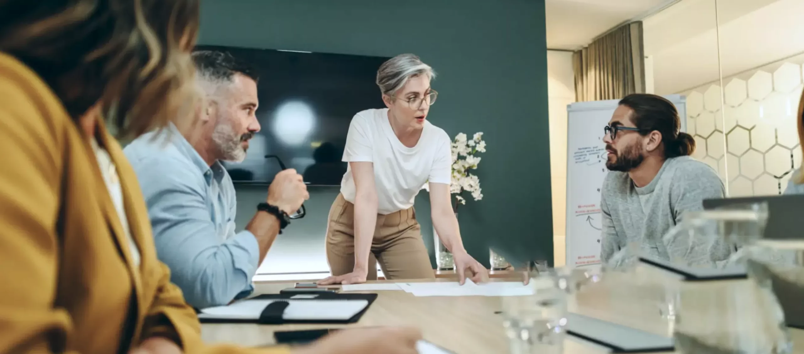 Two women and two men around a table are discussing during a meeting